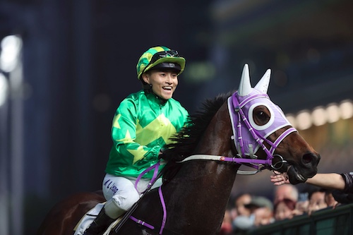 racehorse United Endeeavours returns to scale after winning a race with ear muffs on. happy jockey Keith Yeung